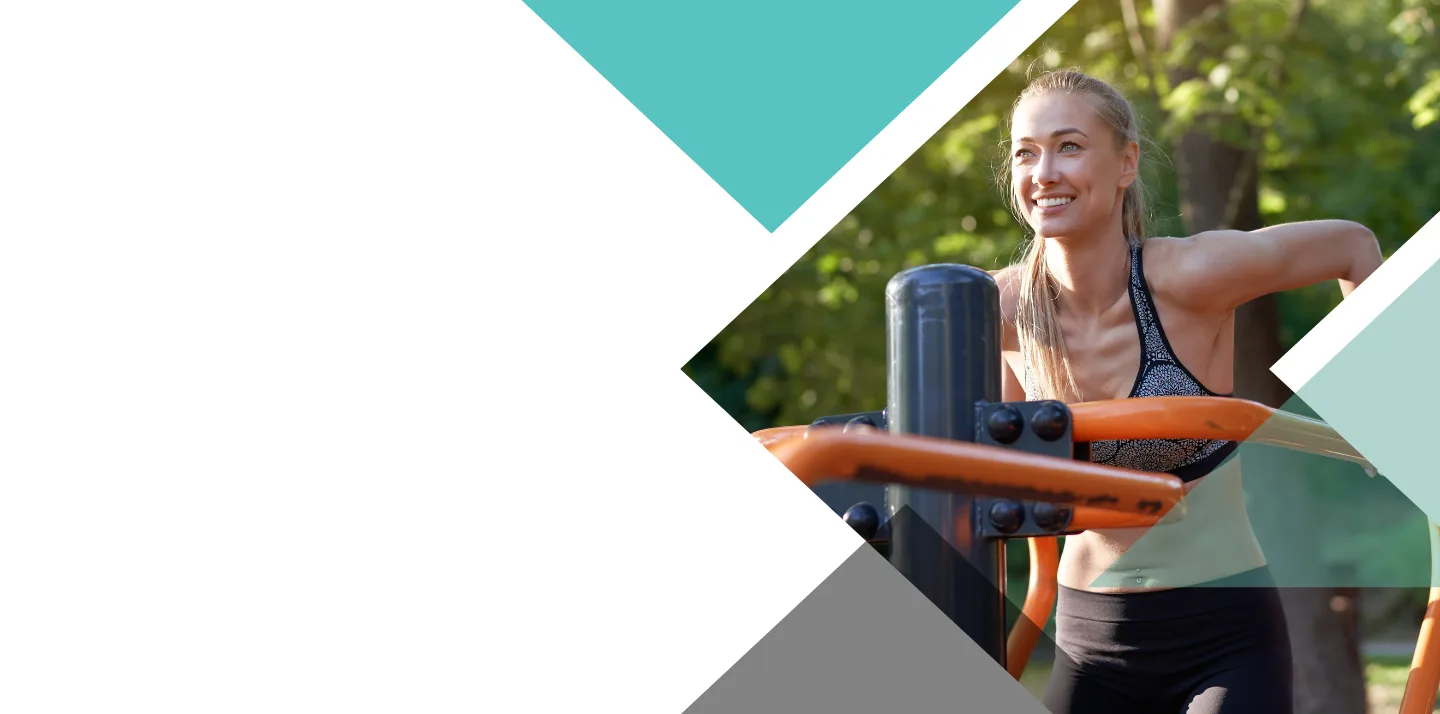 Mulher sorrindo enquanto usa equipamento de ginástica ao ar livre em um parque